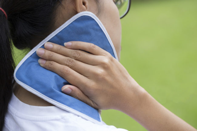woman putting an ice pack on her neck pain hielo-en-la-nuca